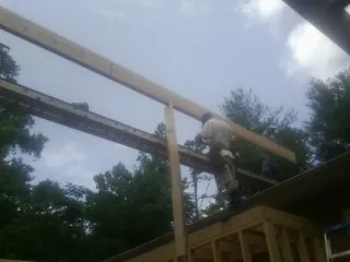 Carpenter setting a ridge beam over a new addition frame — Ice Dam Removal by Roofing Brothers in Atherton