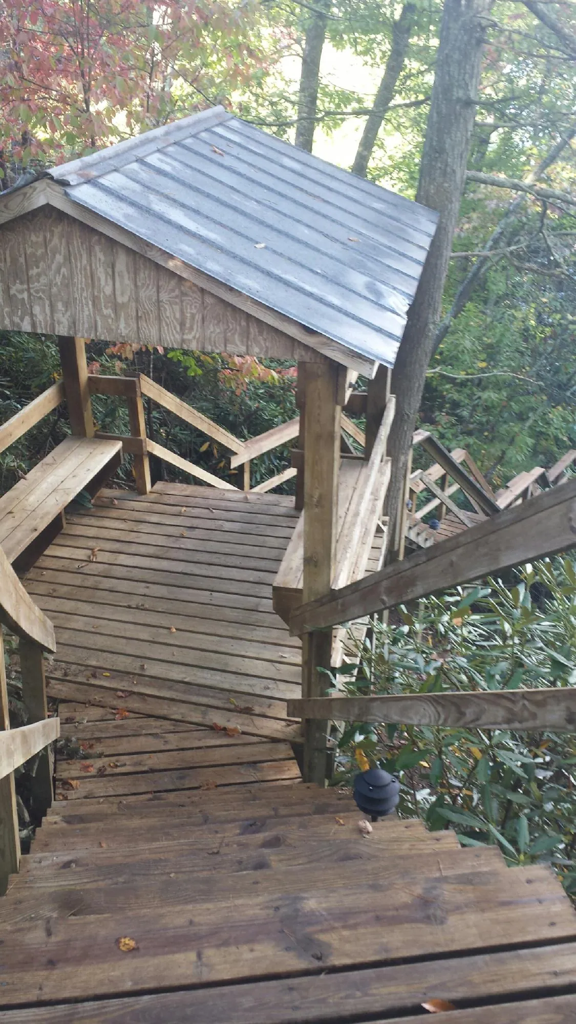 Metal roofed shelter over wooden steps on a wooded walkway — Skylight Repair & Installation work by our crew in Atherton