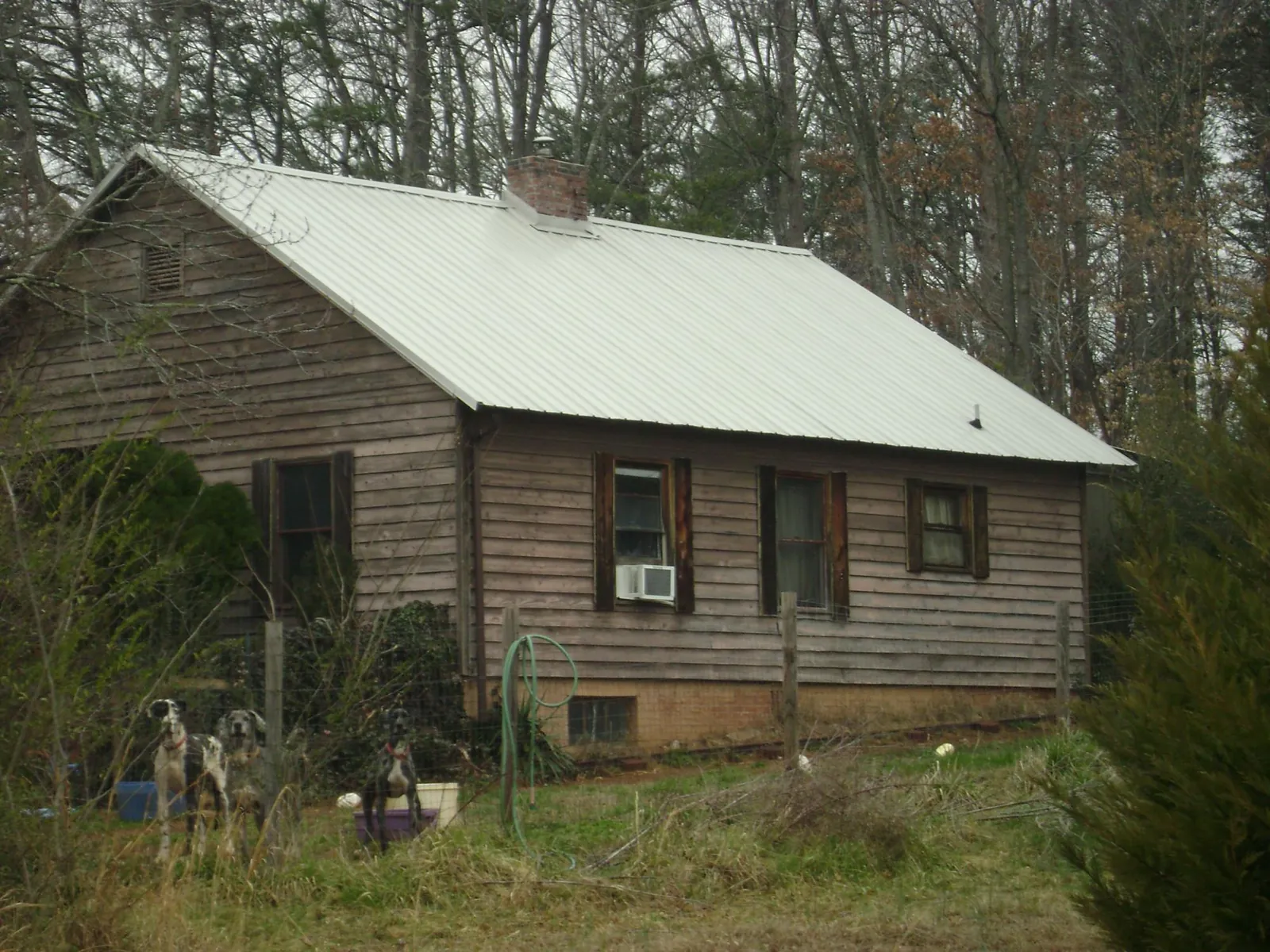 White metal roof on an old wood sided farmhouse, from a Metal Roof Installation job in Atherton